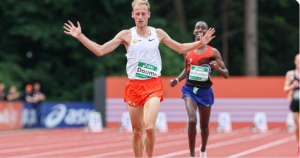 Richard Douma na finish, in oranje broek, wit hemd, armen half opgeheven